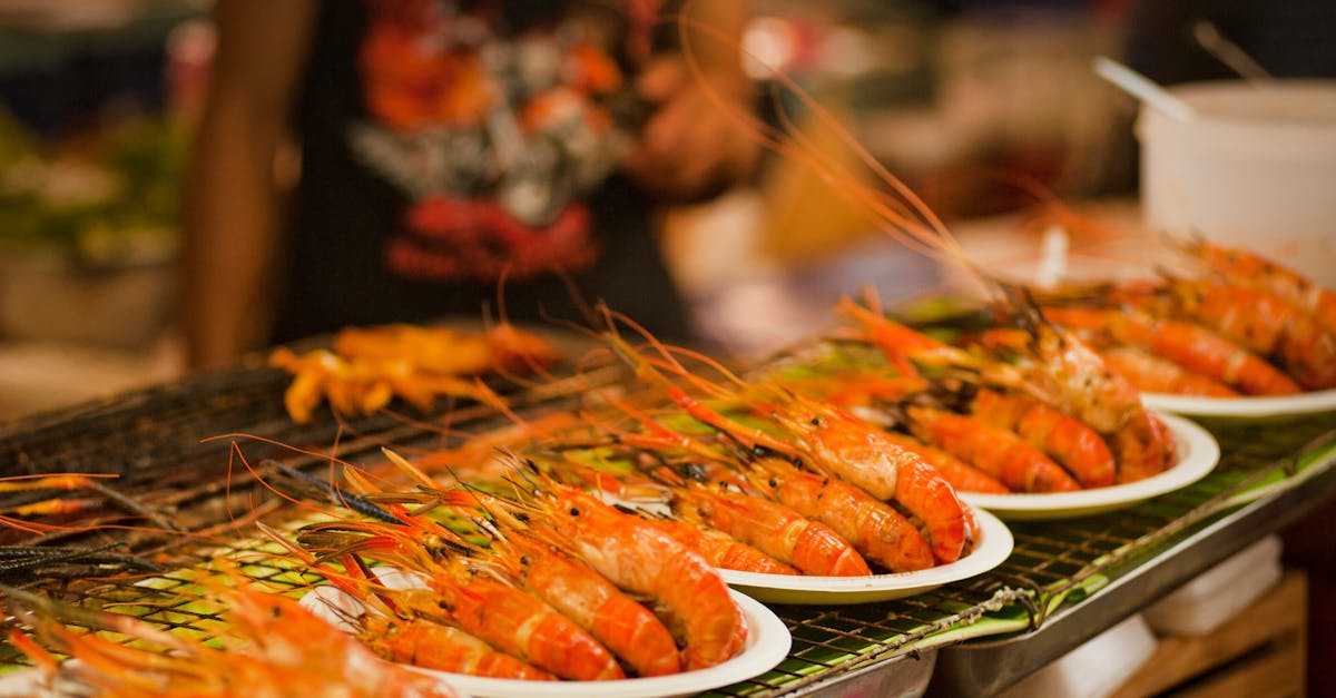 Deliciously grilled shrimps on plates ready to serve at a vibrant Bangkok street food market.