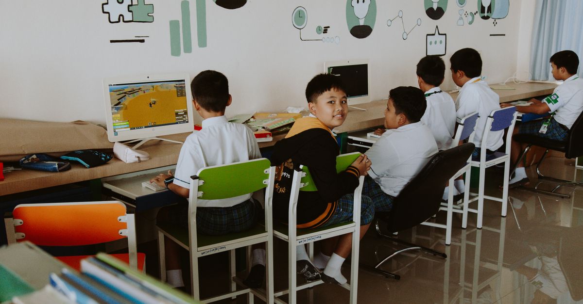 Elementary school students learning in a tech-driven, modern classroom setting.