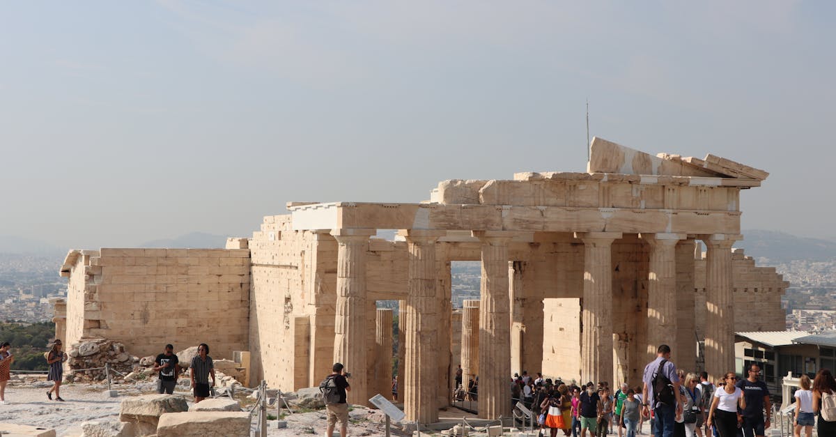 Visitors exploring the historic Propylaea in Athens, a classical Greek architectural marvel.