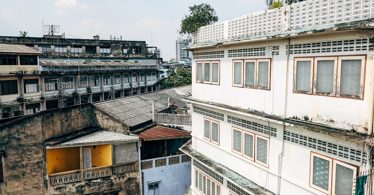 A view of urban residential buildings in Bangkok under a clear sky.