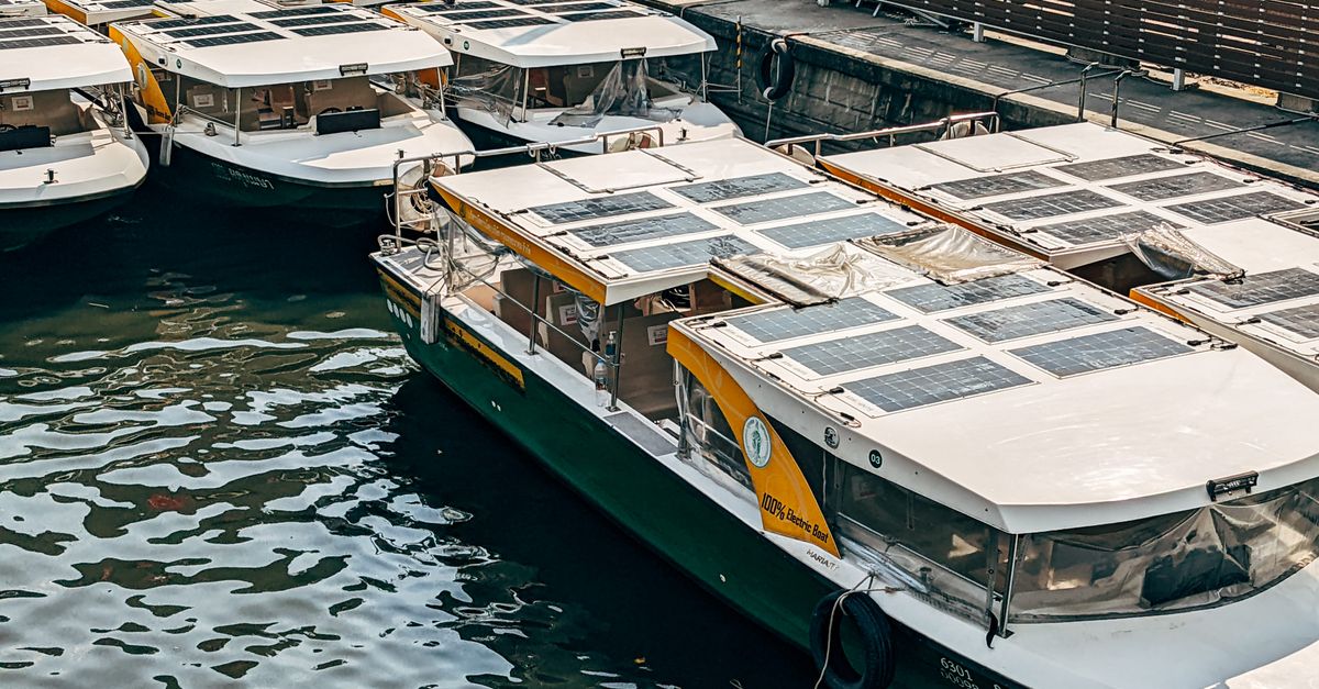 A fleet of solar-powered boats docked at an urban marina, showcasing green transportation.