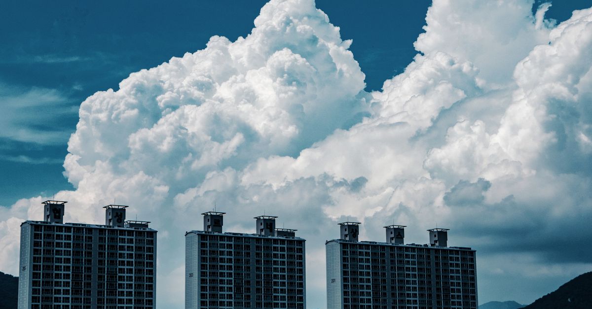 High-rise urban buildings under striking cumulus clouds in a cityscape.