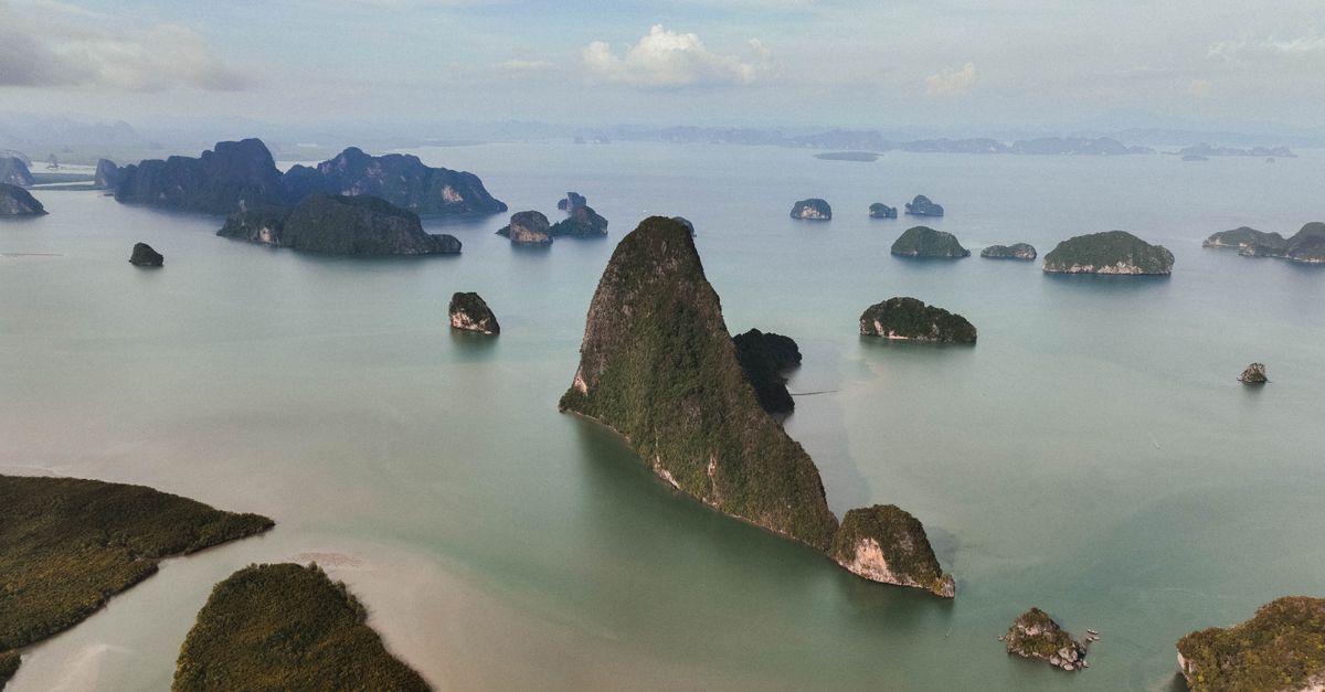 A breathtaking aerial view of lush green islands and calm seas under a cloudy sky.
