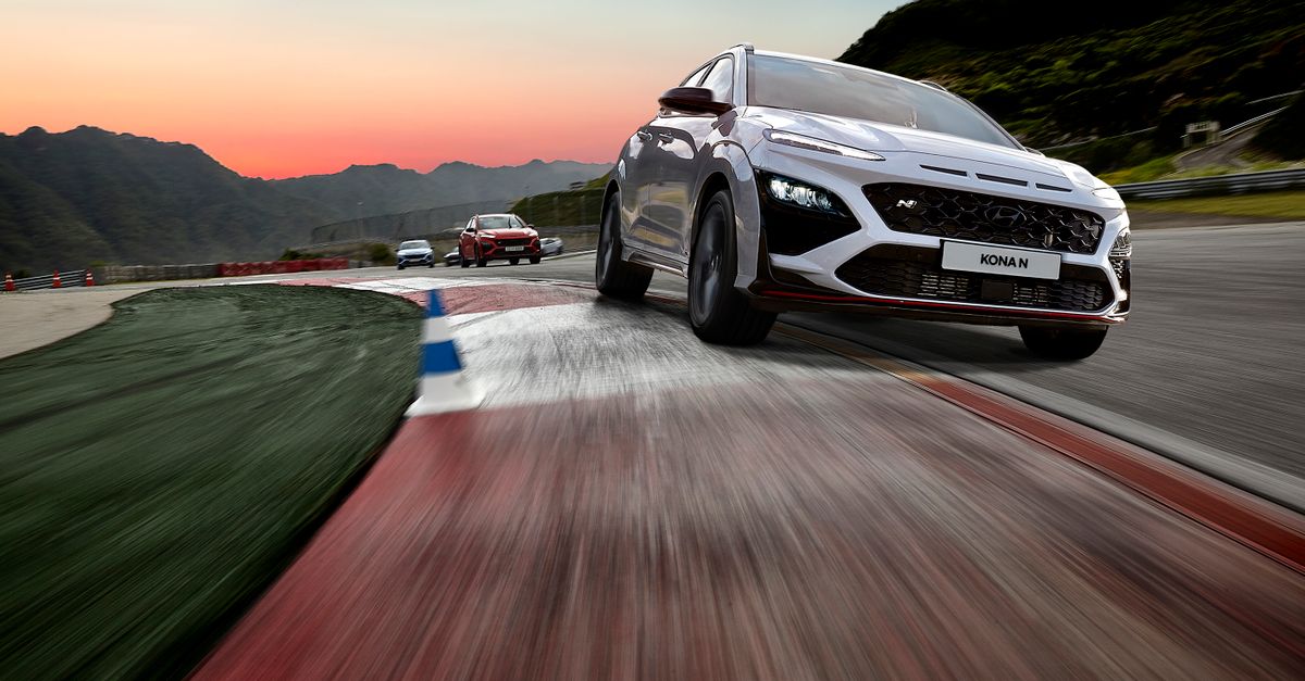 SUVs racing on a track with vibrant sunset backdrop, showcasing motion and speed.