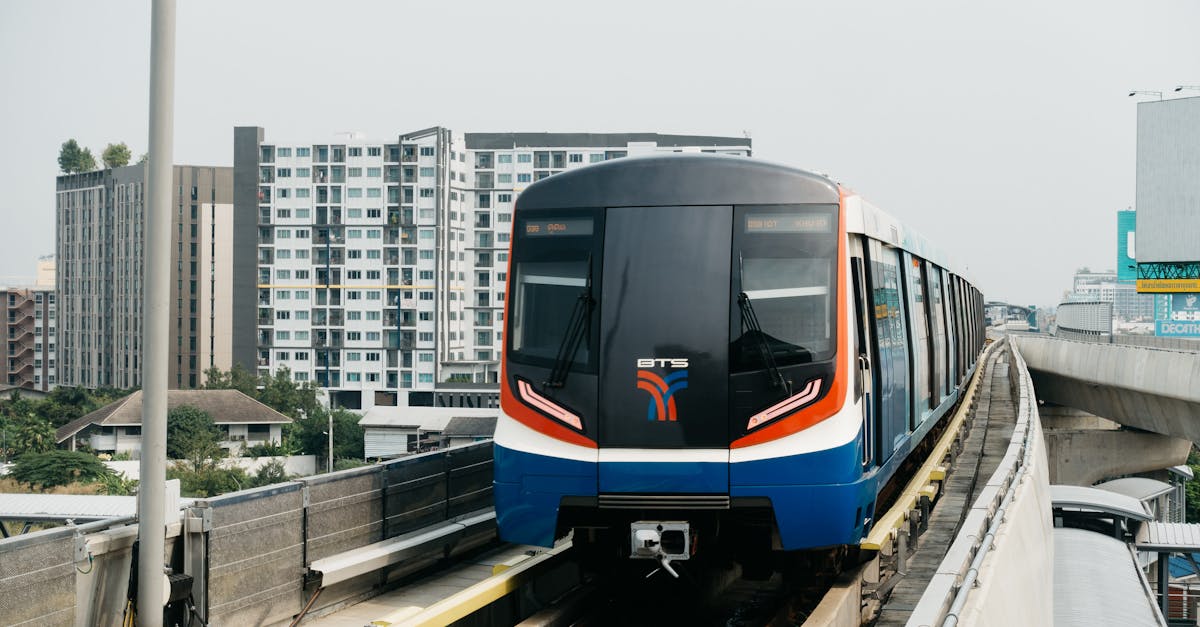Front view of the BTS Skytrain in Bangkok on elevated tracks with cityscape background.