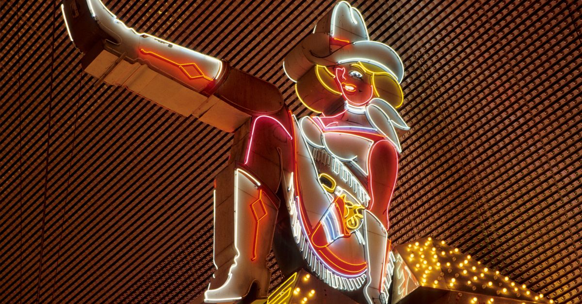 Vivid neon cowgirl sign in Las Vegas, showcasing iconic nightlife.