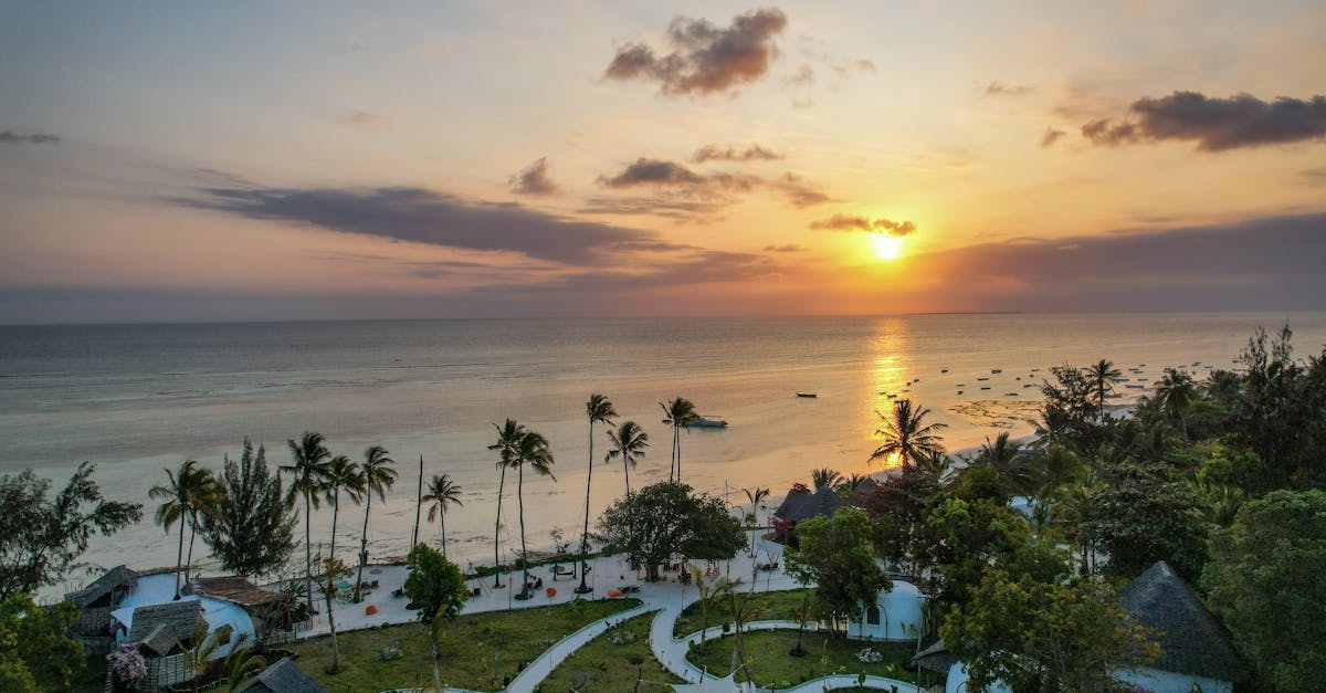 A breathtaking aerial view of Kizimkazi Beach at sunset, showcasing vibrant skies and serene waters in Tanzania.