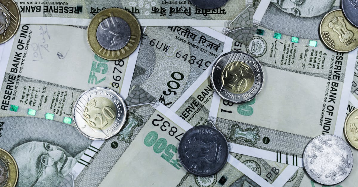 Top view of various Indian rupee banknotes and coins, highlighting financial themes.