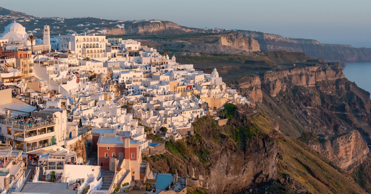 Aerial view of Santorini's stunning clifftop architecture at sunset.