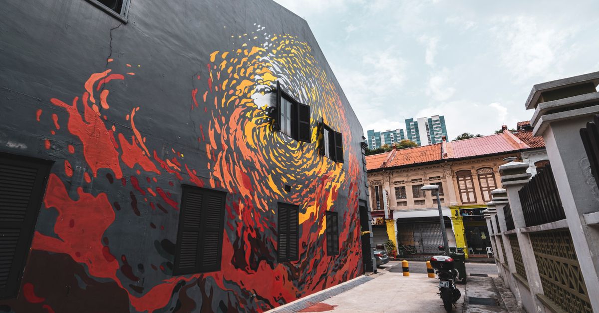 Colorful mural on building facade in urban alleyway, showcasing vibrant street art.
