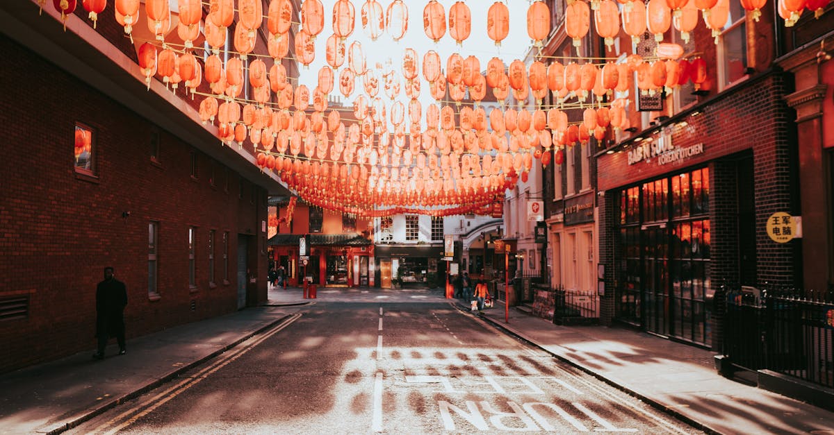 Street with hanging red lanterns in London's Chinatown, showcasing rich cultural heritage.