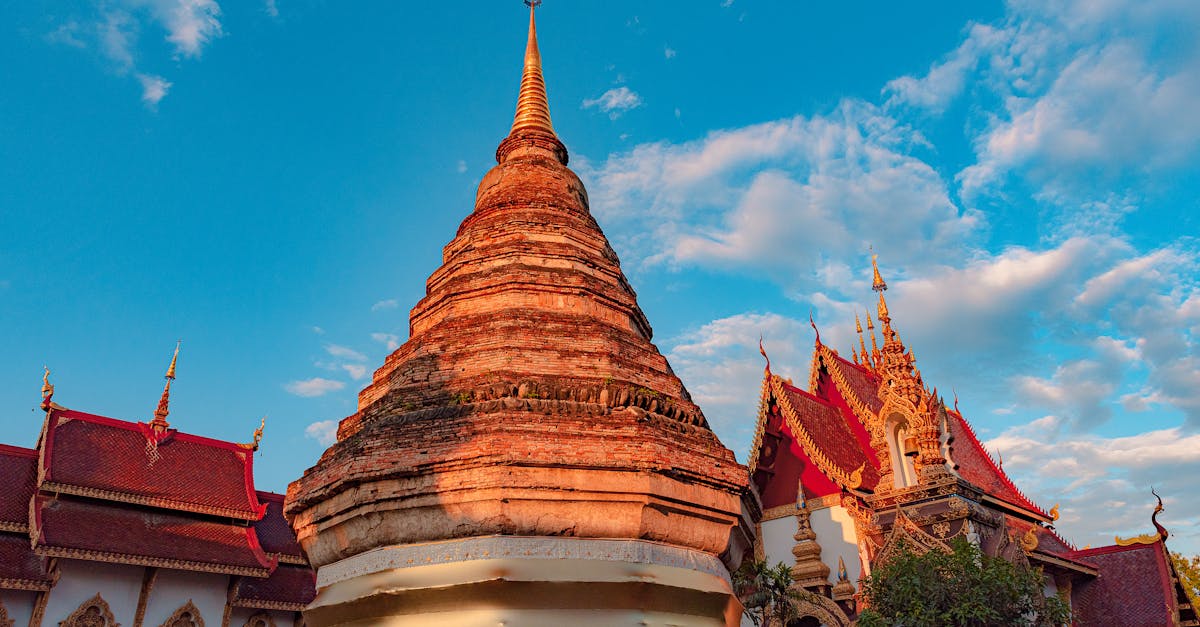 Stunning view of a traditional Buddhist temple against a bright blue sky in Chiang Mai, Thailand.