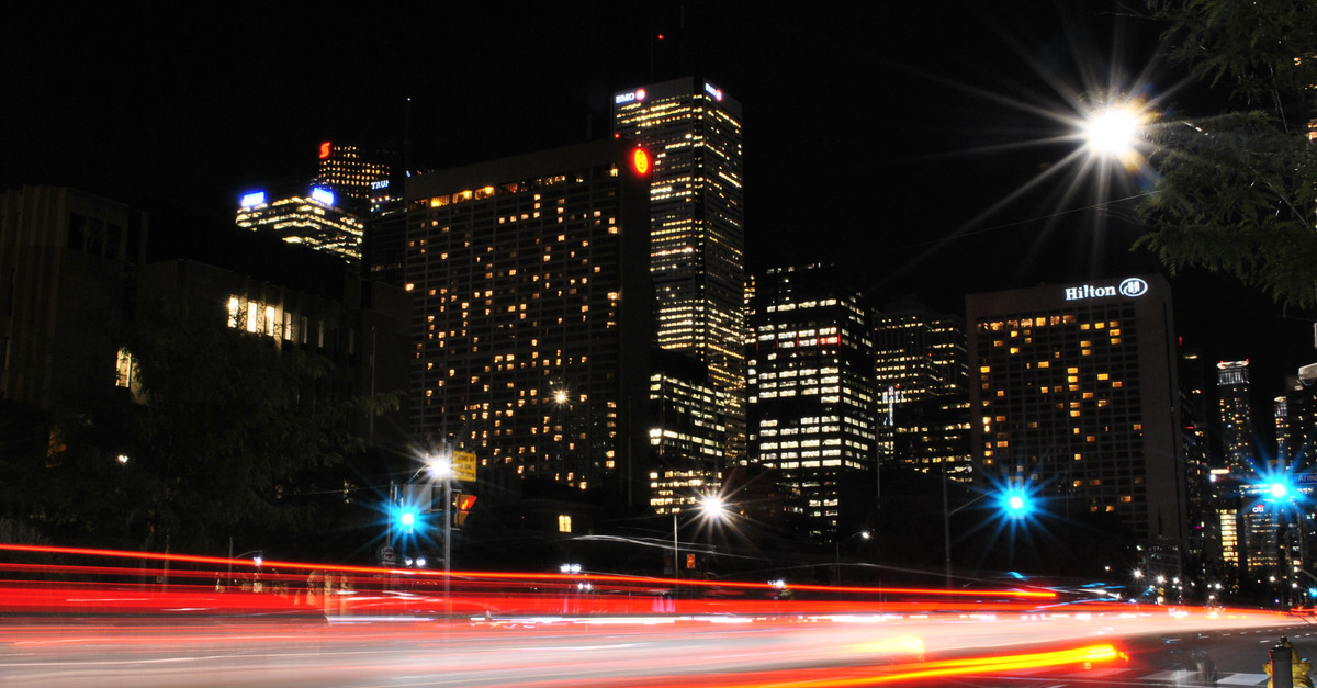 Dynamic urban night scene showcasing light trails against a lit city skyline.