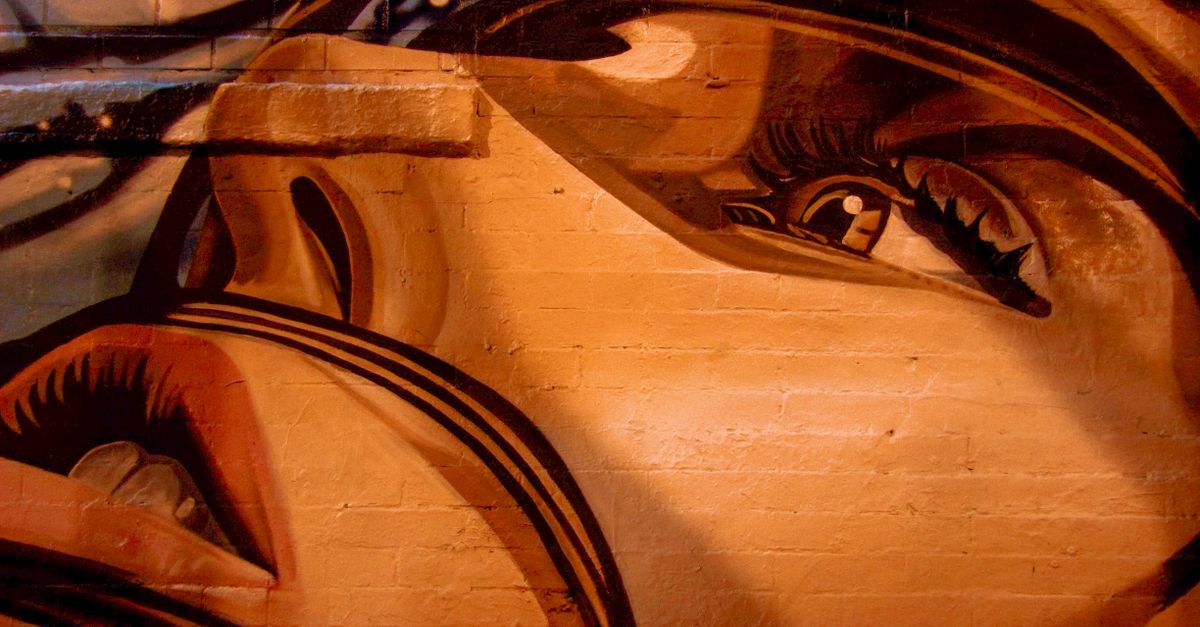 Colorful mural of a face showcasing vibrant street art on a city wall.
