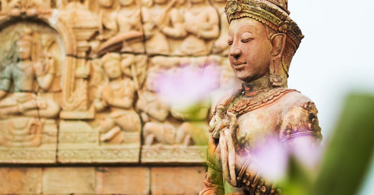 Close-up of an intricate Buddhist sculpture against a detailed temple wall.