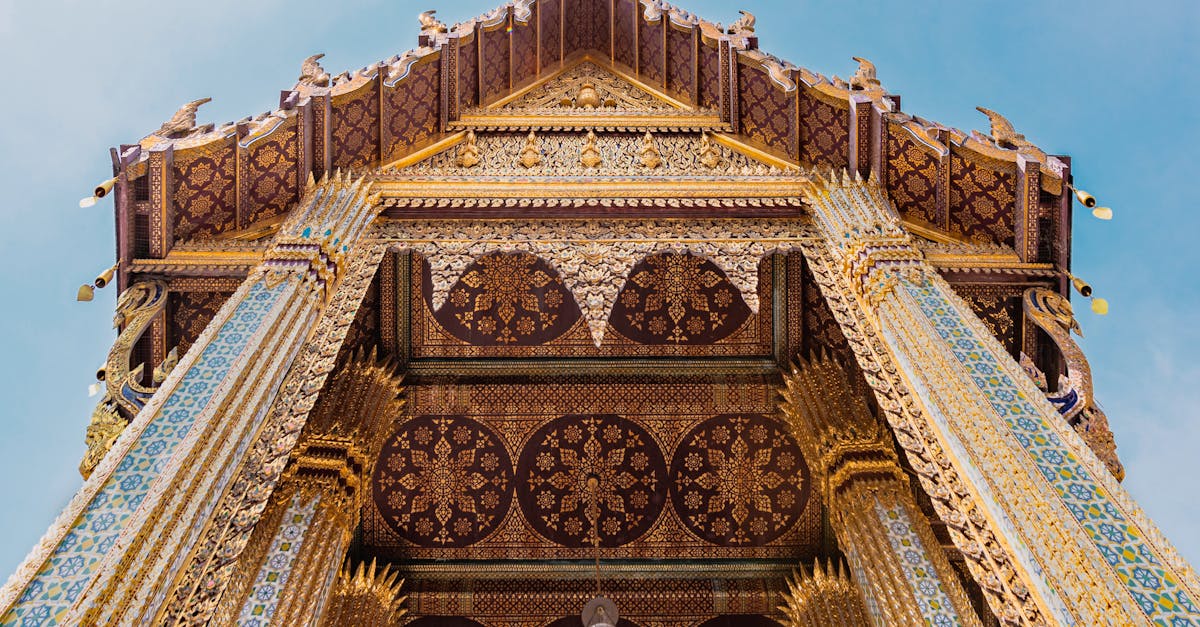 Stunning low-angle view of a beautifully decorated temple in Bangkok, showcasing intricate Thai architecture.