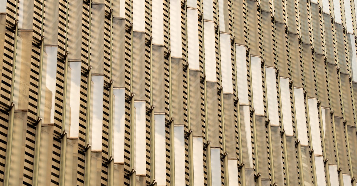 An abstract view of a modern golden facade with intricate geometric patterns in daylight.