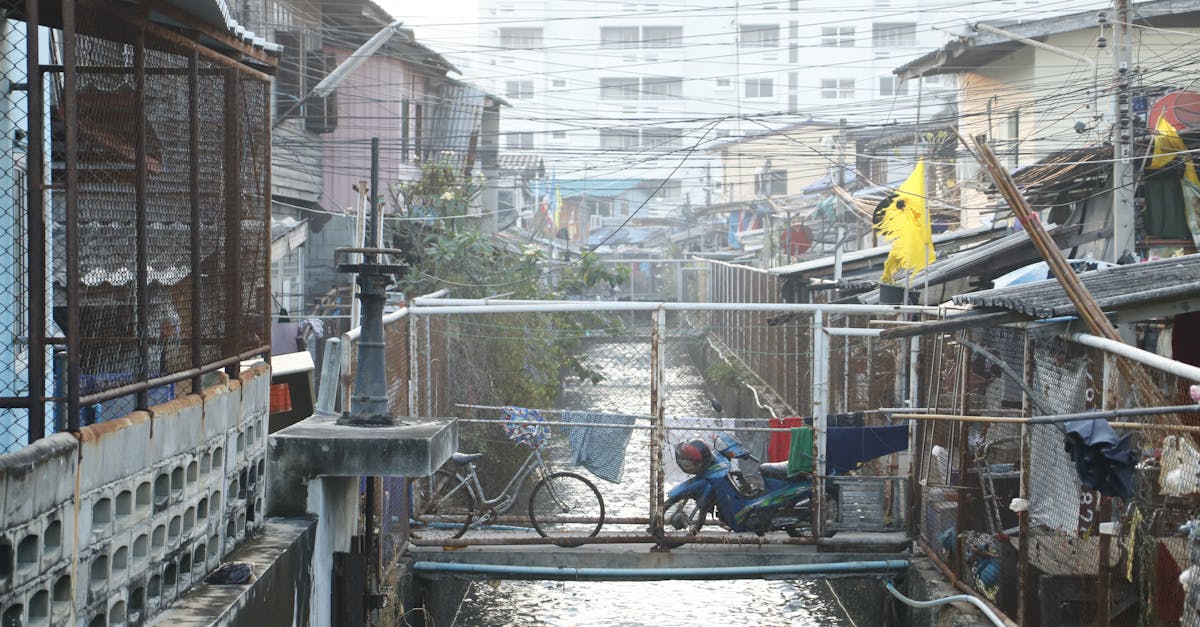 A busy urban canal with makeshift bridge crossing and residential buildings.
