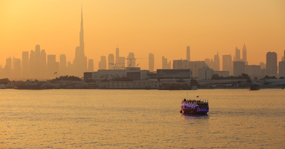 Stunning Dubai skyline with Burj Khalifa during sunset, featuring a lit dhow in the foreground.