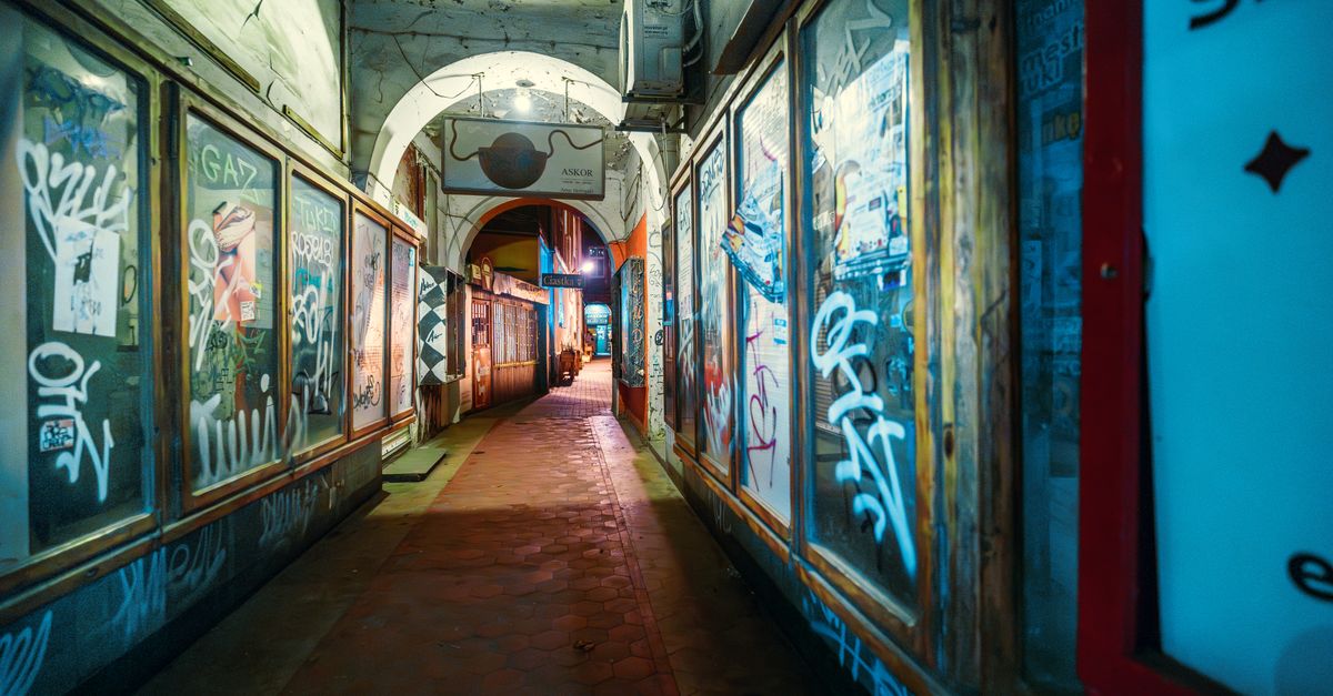 Urban graffiti alley in Poznań, Poland. Narrow path with artistic walls and vibrant colors.