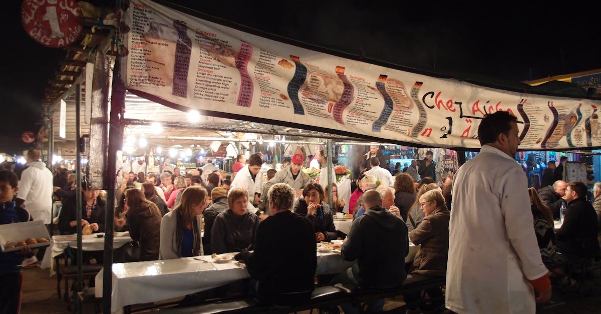 Crowded dining scene at an outdoor market in Morocco, showcasing lively nightlife and cultural interactions.