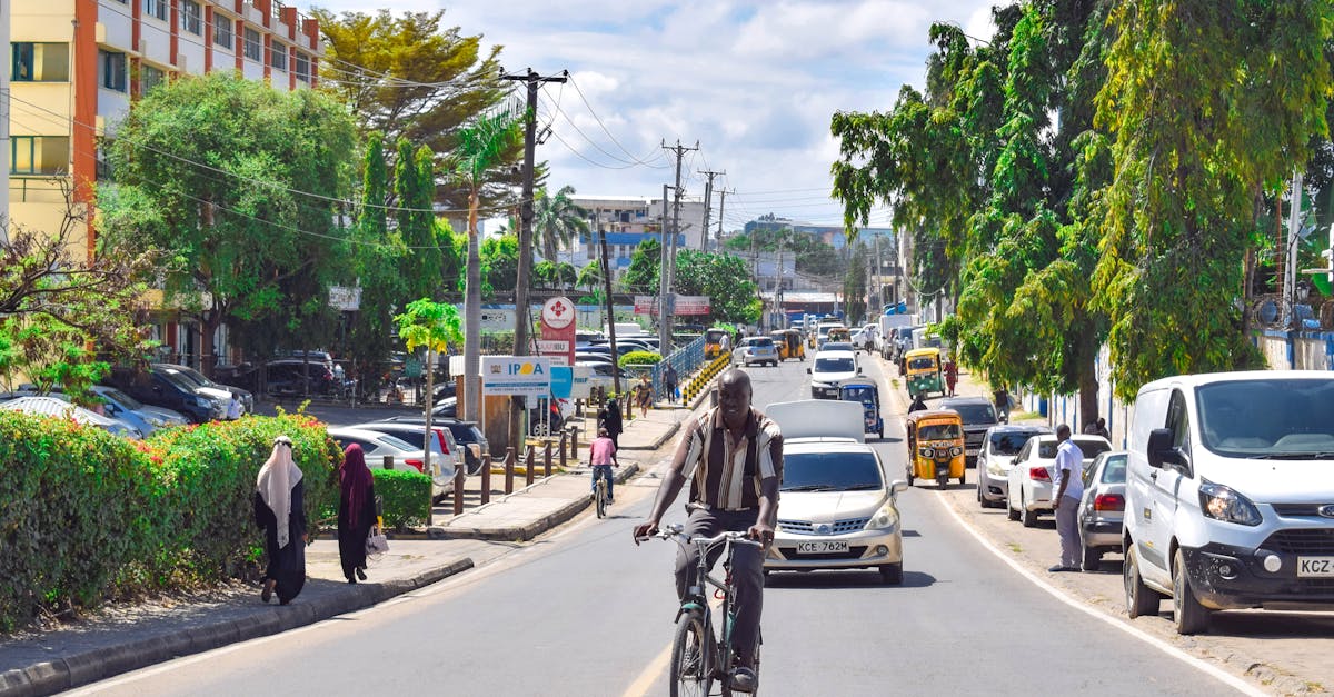 A vibrant street scene in Mombasa, Kenya with a cyclist riding amidst the urban bustle.
