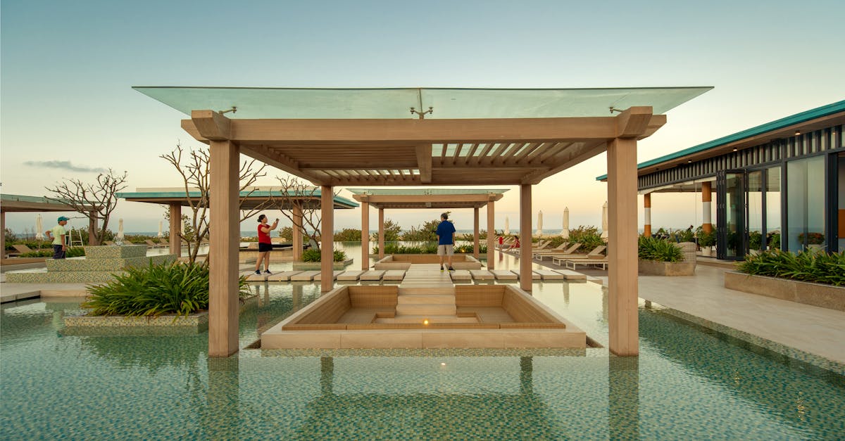 Elegant resort pool area with tourists and modern design at sunset in Vietnam.