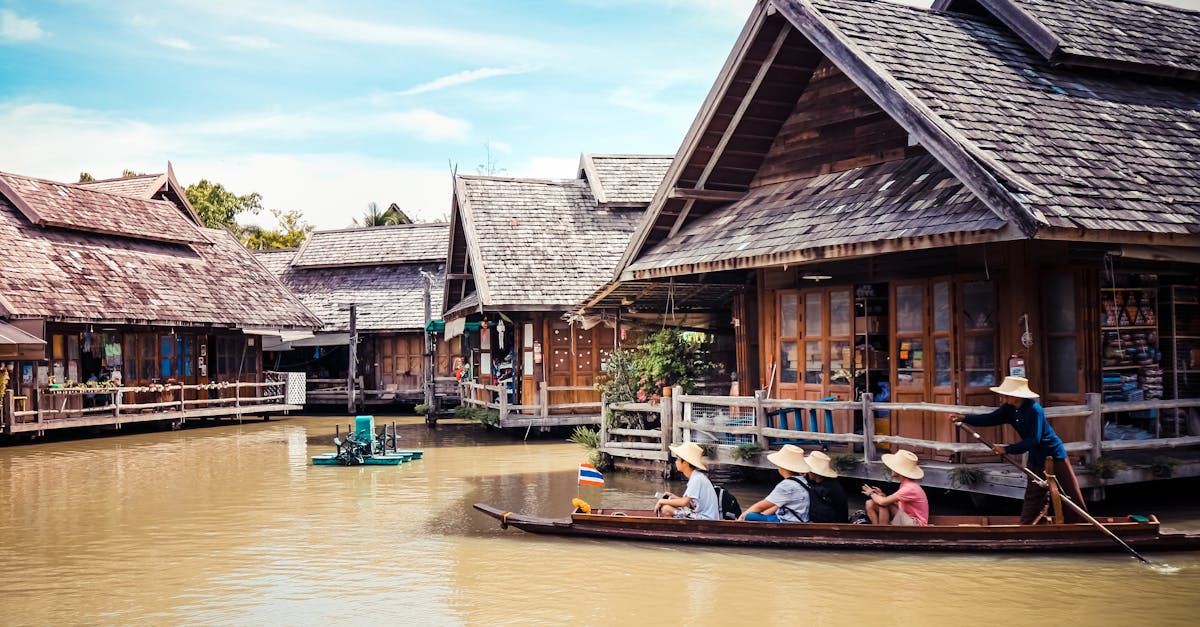 Explore the vibrant and traditional floating market in Thailand, with wooden houses and tourists on boats.