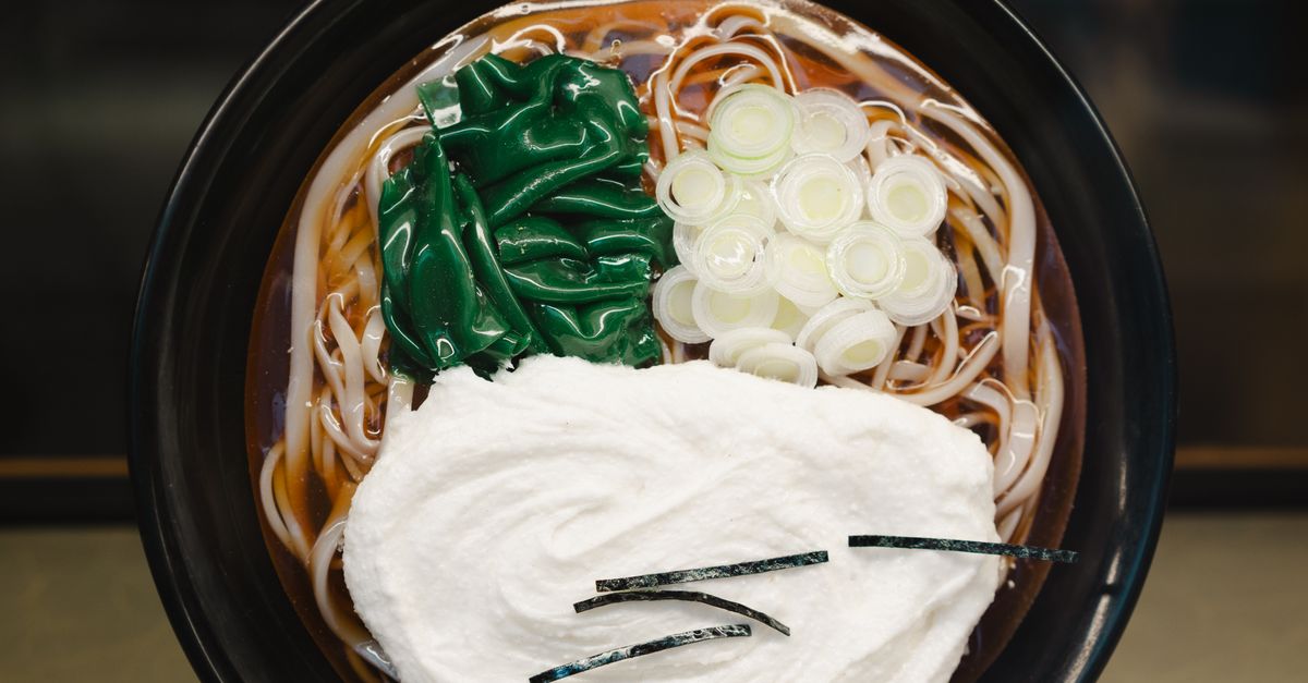 Top view of a savory bowl of Korean ramen soup with seaweed, noodles, and cream topping.