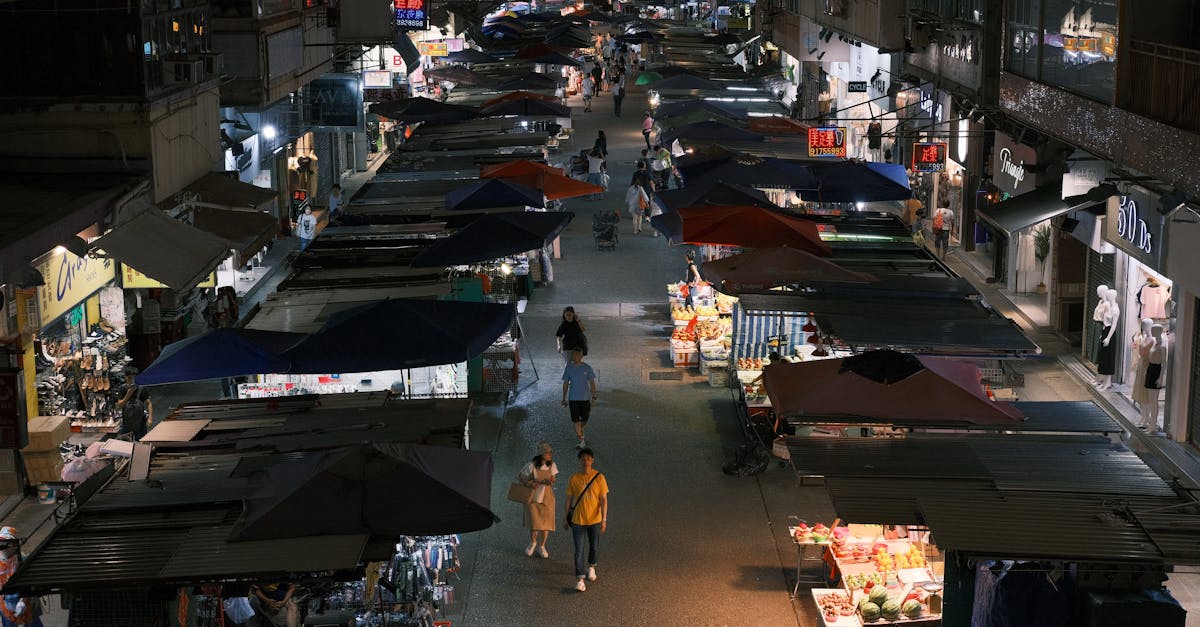 Bustling night market street with vibrant stalls and pedestrians in an urban setting.