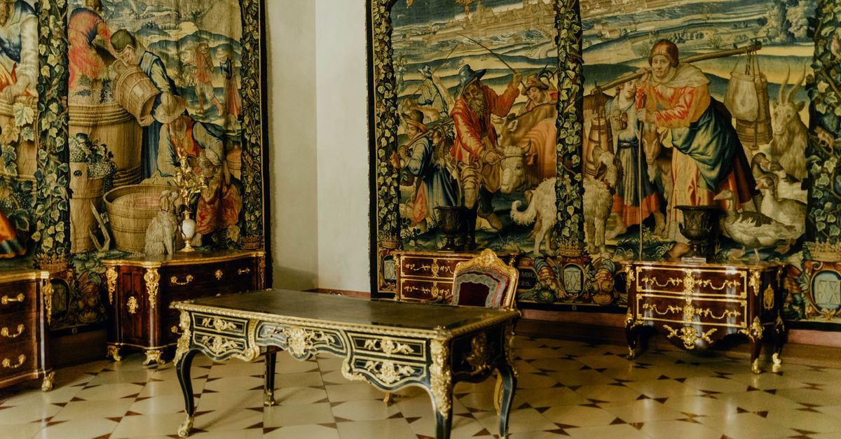 Luxurious room featuring ornate tapestries, antique furniture, and detailed gold accents, capturing historic elegance.