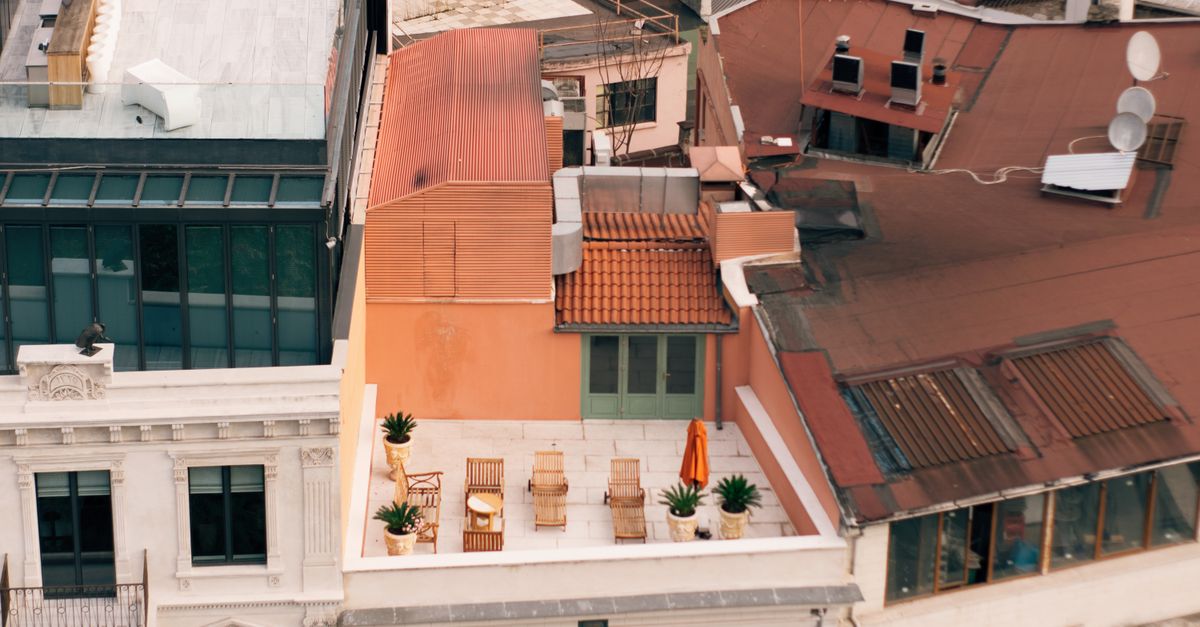 Aerial view of a cozy urban rooftop terrace with seating and plants.