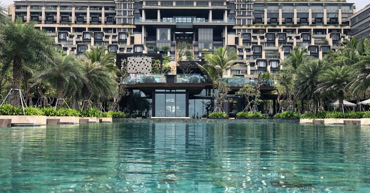 Stunning luxury resort with infinity pool and lush palm trees, perfect for a tropical getaway.