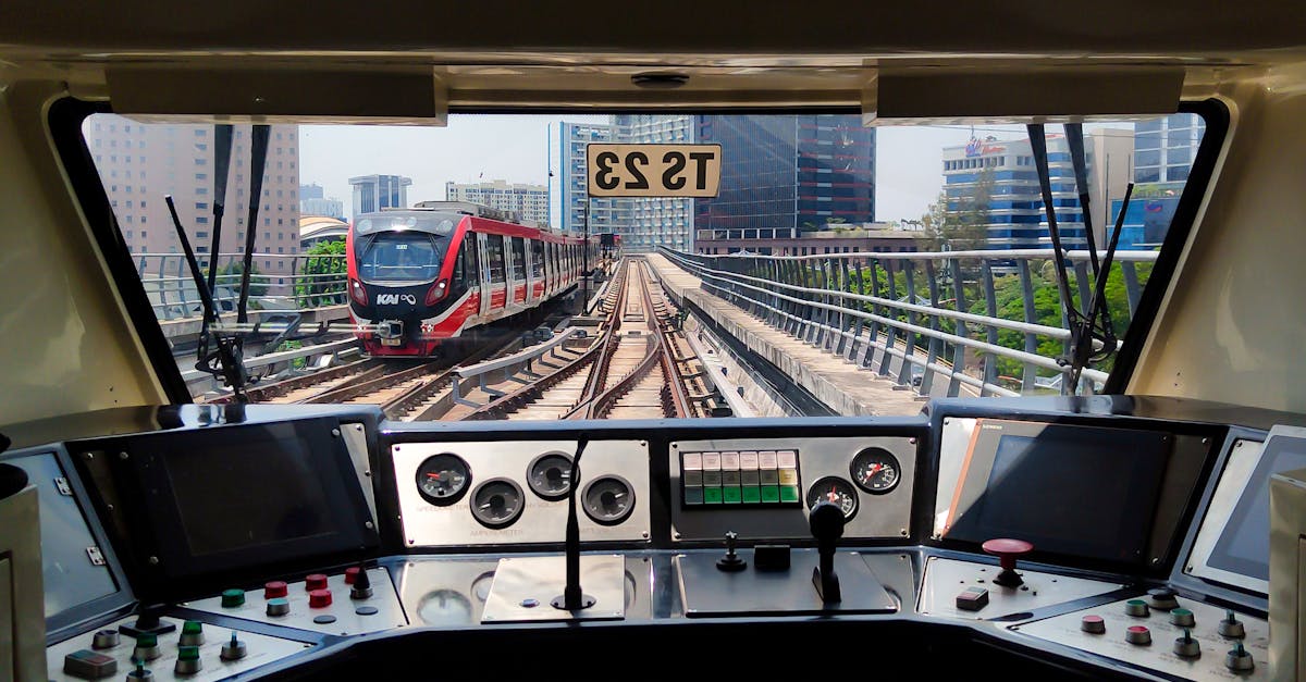 View from a train cockpit with city skyline in the background.
