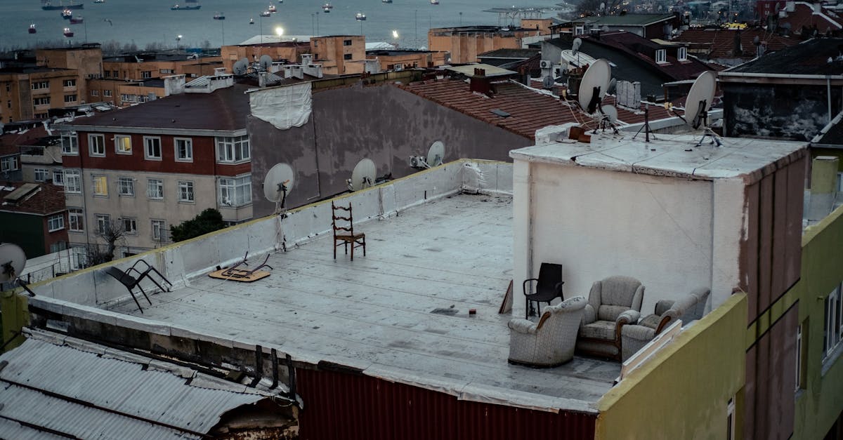 Rooftop scene showing urban landscape with sea view and boats in the distance.