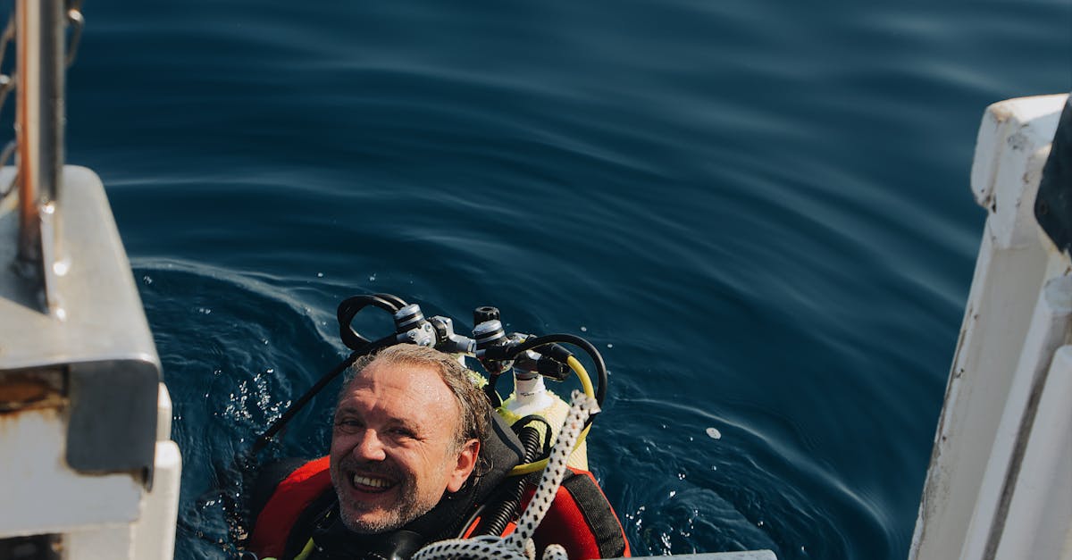 A joyful scuba diver emerges from the ocean, smiling at the camera.