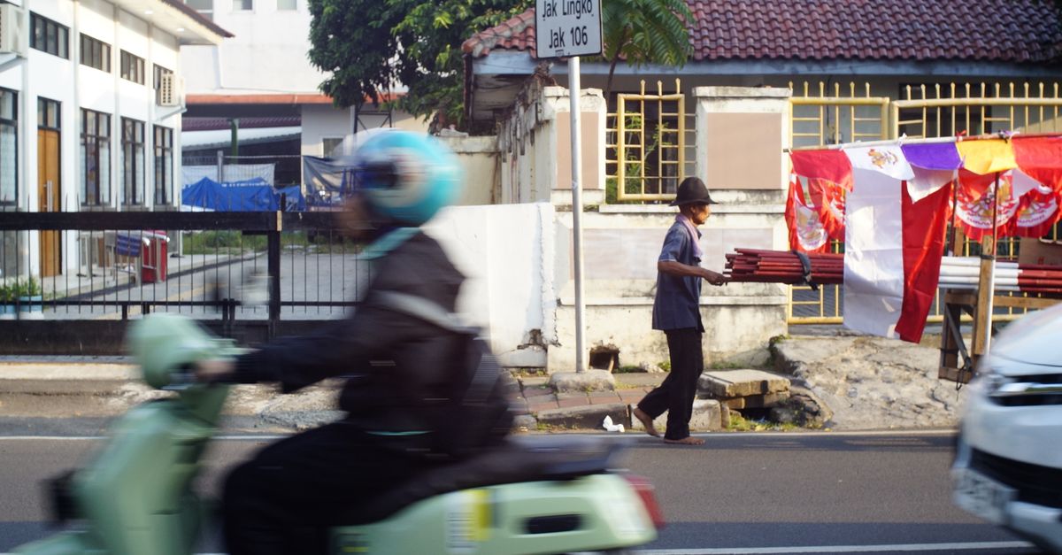 A busy urban street with a motorbike and vendor, showcasing dynamic city life.