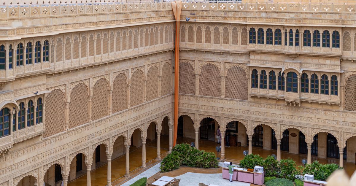 Explore the intricate sandstone architecture of a Jaisalmer heritage hotel courtyard.