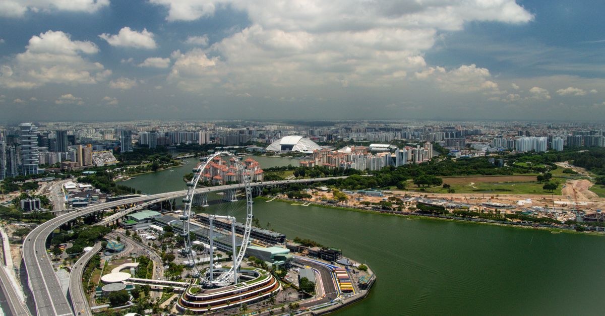 A stunning aerial view of Singapore's skyline showcasing the iconic Singapore Flyer and vibrant urban landscape under a clear sky.