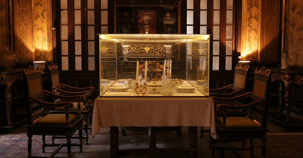 Elegant antique dining room featuring ornate furniture and illuminated glass case display.