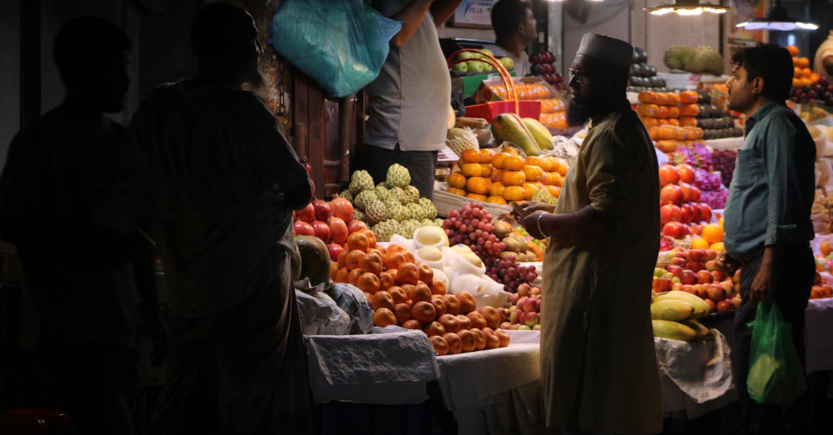 Night market scene with diverse fruits and vendors under artificial lighting.