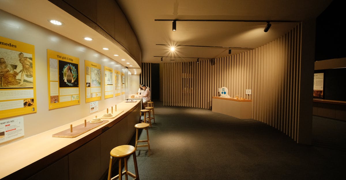 Quiet museum interior featuring educational displays and stools under warm lighting.