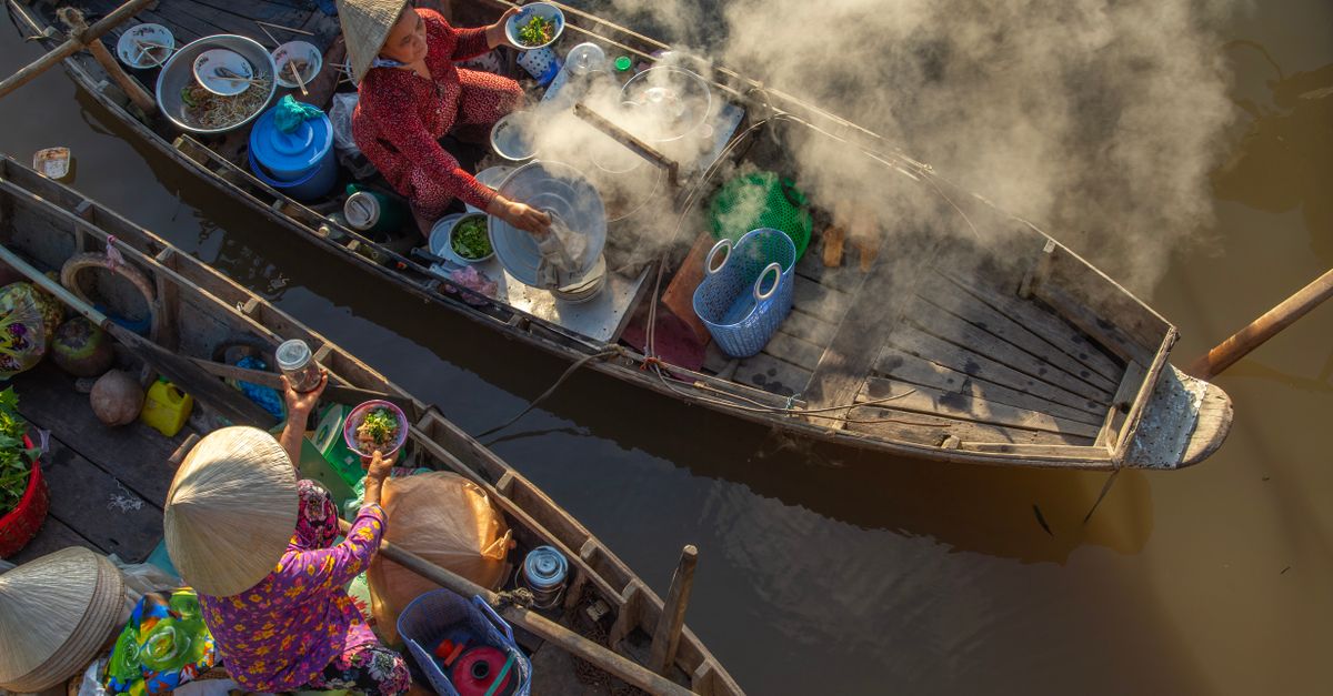 A vibrant scene of a traditional floating market in Vietnam, showcasing street food vendors on boats.