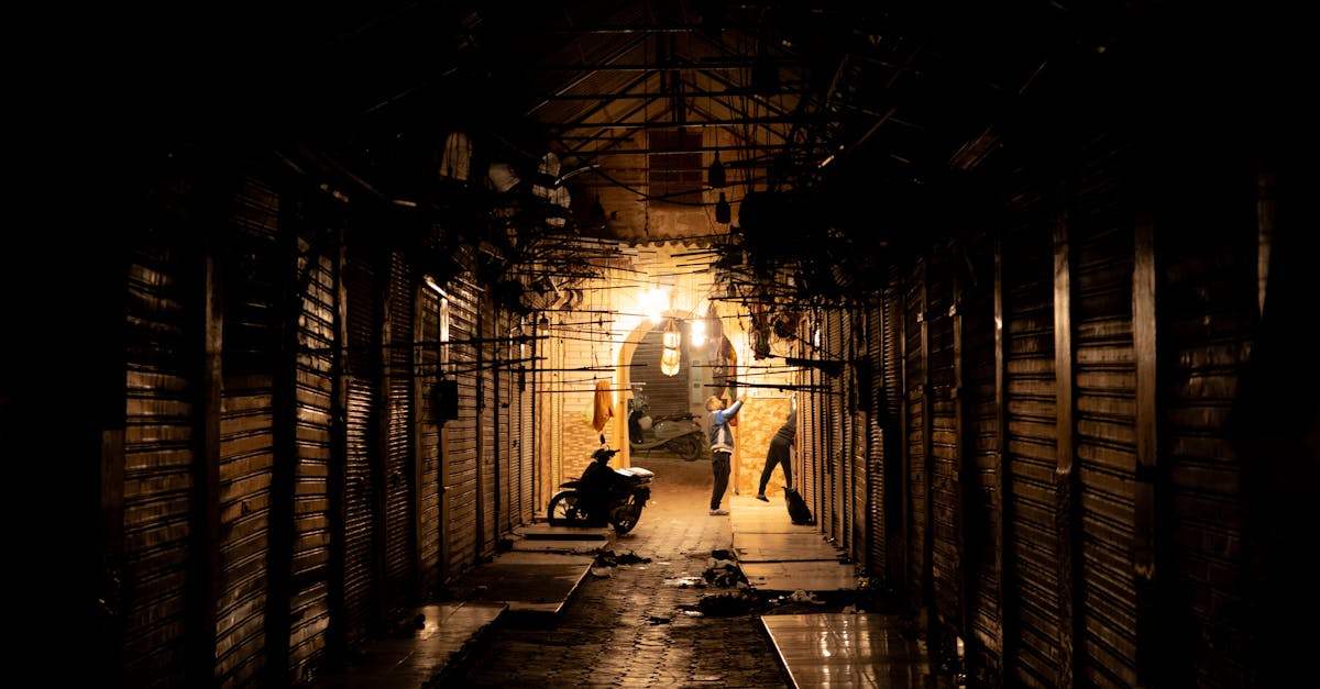 A dimly lit alleyway in Marrakech Medina at night, showcasing local life and architecture.