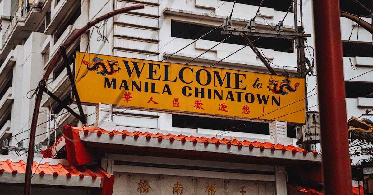 Bright yellow welcome sign at historic Manila Chinatown, featuring traditional architectural elements.