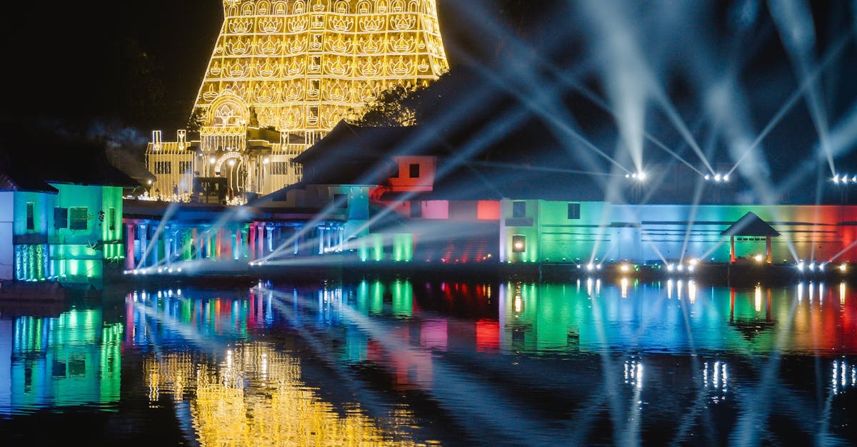 Stunning nighttime illumination at Padmanabhaswamy Temple with vibrant reflections.