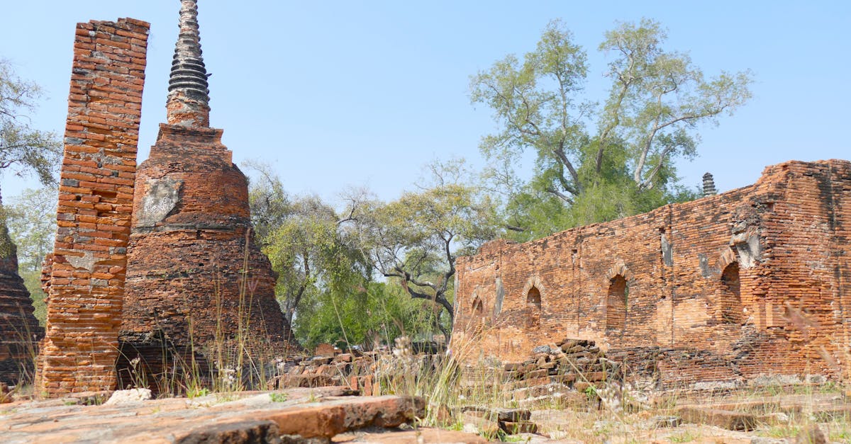 A serene view of historic brick ruins and pagoda under a clear blue sky, showcasing ancient architecture.