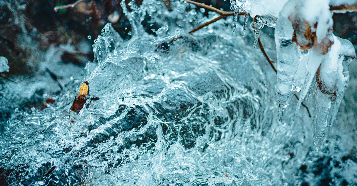 Close-up of ice formations and freezing water flow in a winter landscape.