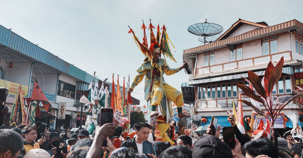 Vibrant traditional festival parade in Singkawang, West Kalimantan, featuring colorful costumes and crowd.