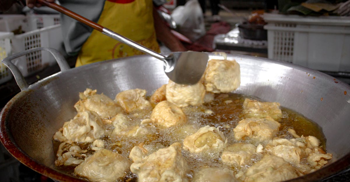 Fried tofu being prepared in a street market for a crispy snack.